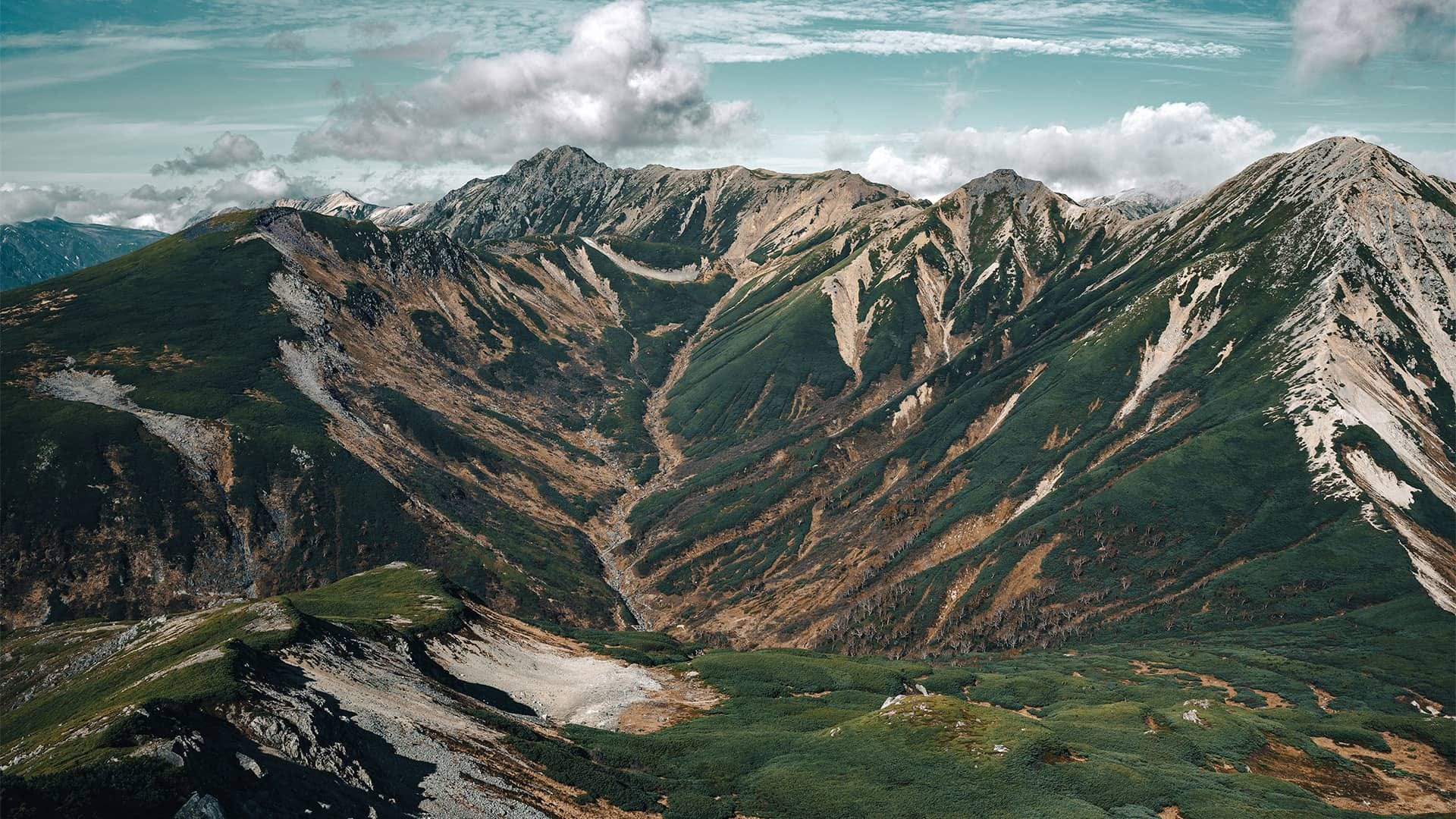 A mountain ridge covered in low-growth vegetation.