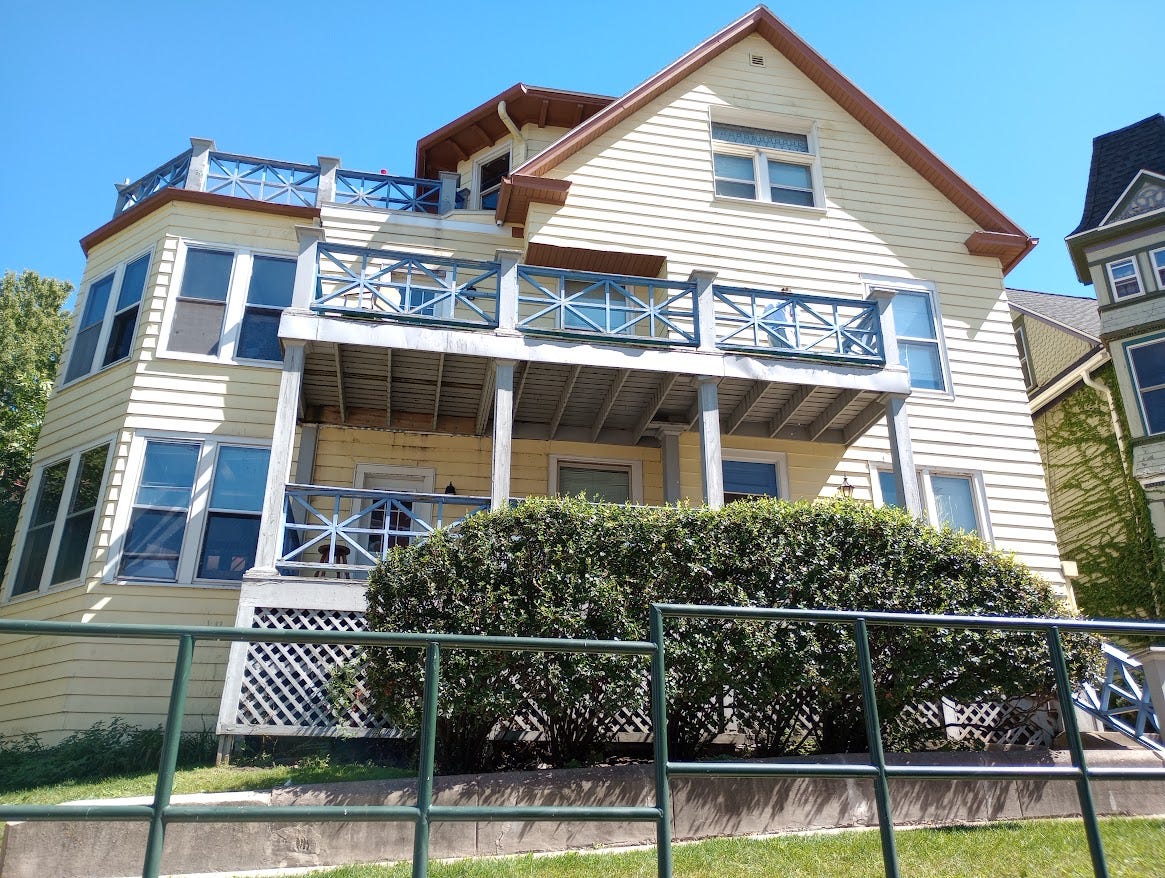 Large two-story house with balconies on hillside