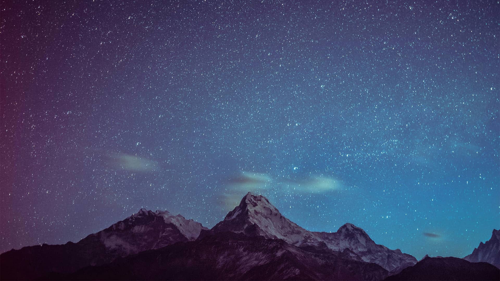 Rocky mountaintops under a starry night.