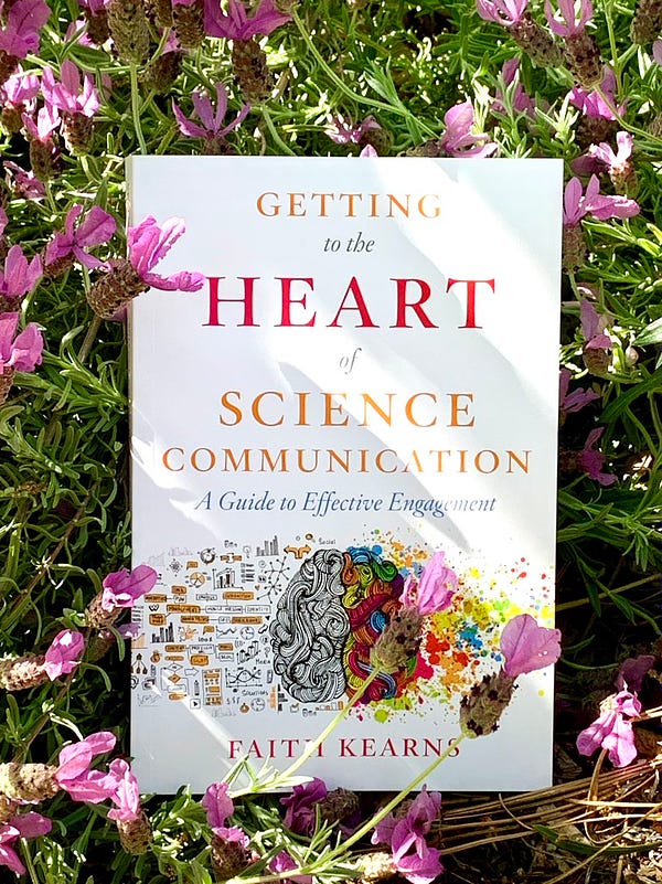 The cover of Dr. Faith Kearns new book “Getting to the Heart of Science Communication.” The book is sitting in dappled sunlight in a bed of lavender flowers.