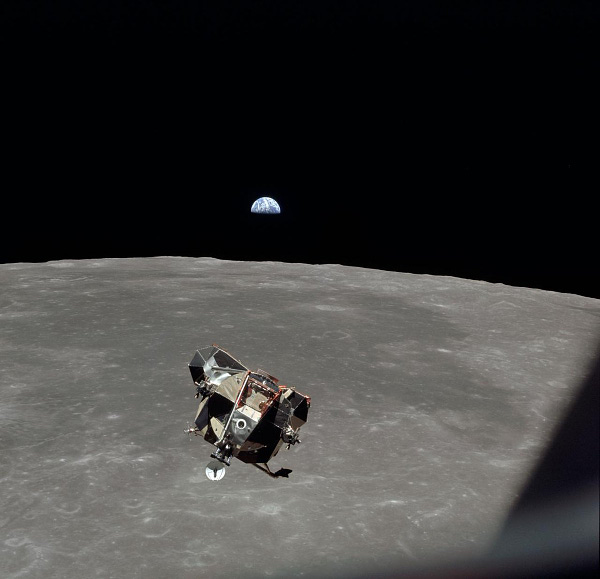 Lunar module with gray Moon in background and Earth rising in the distance. 