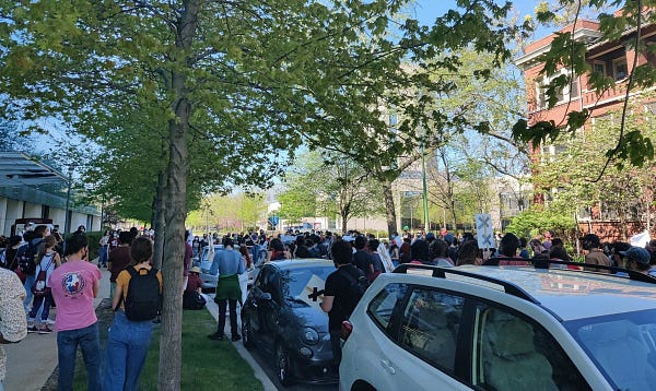 A massive crowd gathers in front of UCPD police station with picket signs to hear from speakers from Care Not Cops, Tenants United speak about police violence