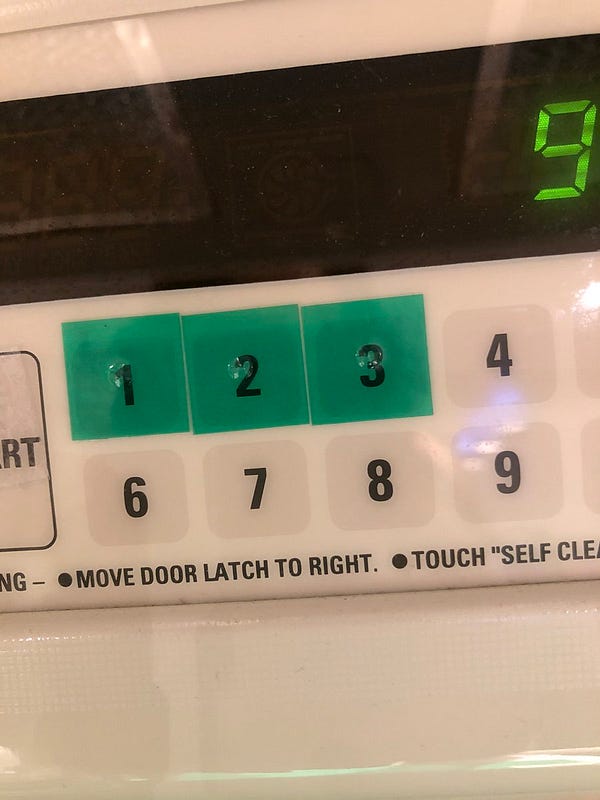 Green tactile stickers on touch pad of oven