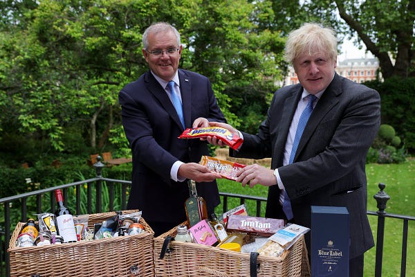 Boris Johnson and Scott Morrison exchange Tim Tams and Penguin biscuit's in the Downing Street garden.