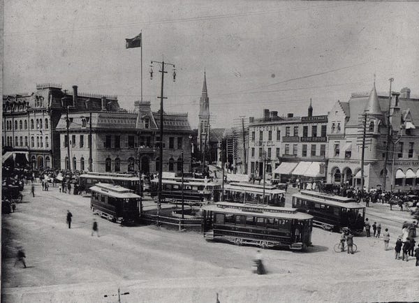 Cabinet photograph with cream coloured mount. St. George's Square showing Blacksmith Fountain and street cards, post office, St. George's Church, Victoria Hotel, Alex Stewart's Drug store, Canadian Bank of commerce, horses and buggies- no automobiles; arc street lamps.