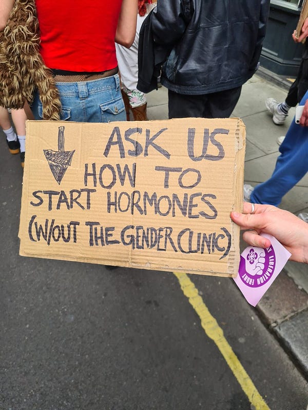 A sign reads "ask us how to start hormones without the gender clinic"