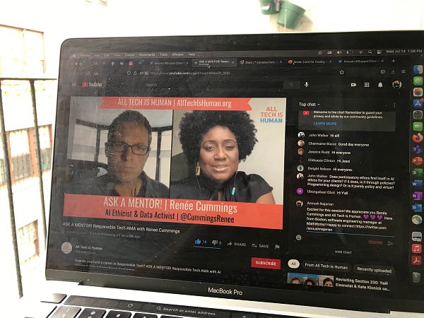 Photo of laptop running YouTube Live session with video of speaker and moderator and comments.