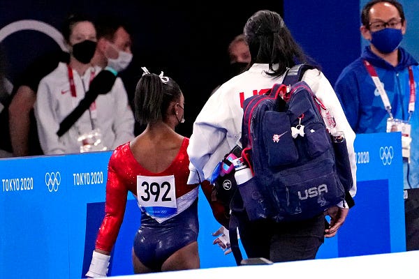 Simone Biles leaves the event with a coach.