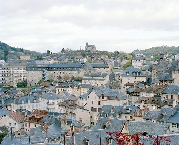 photograph of a beautiful town in Tulle, France from a very high vantage point in the hilly area of all the blue and grey rooftops during summer 2017