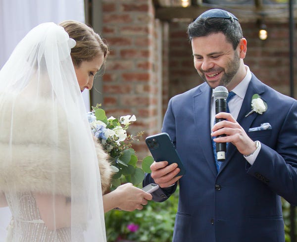 Rebecca and Peter exchanging digital rings from their cryptocurrency wallets at their wedding