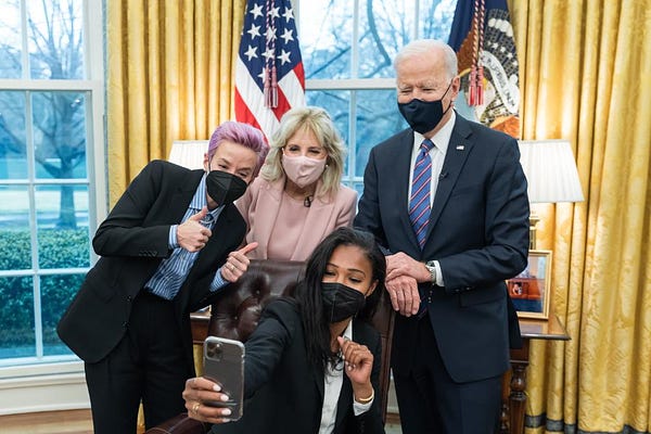 President Biden and First Lady Jill Biden pose for a selfie with Megan Rapinoe and Margaret Purce in the Oval Office