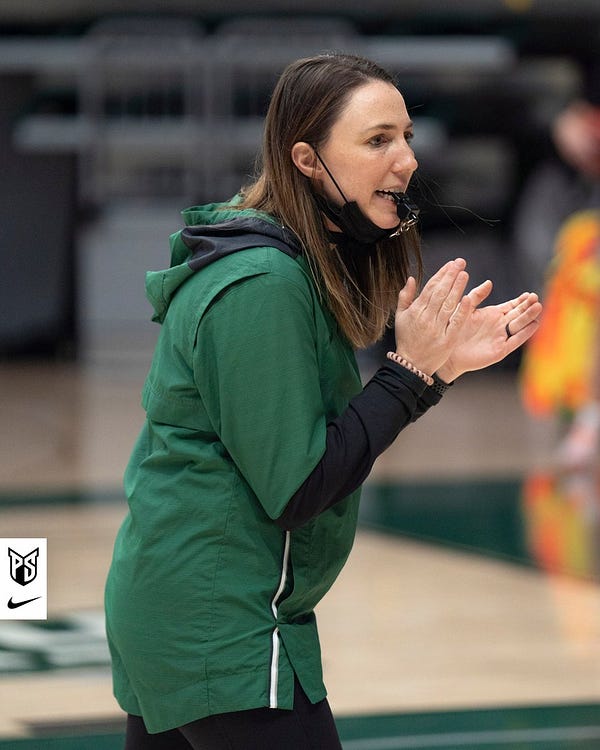 Action photo of Portland State women's basketball head coach Chelsey Gregg clapping as her team goes through a drill in practice.