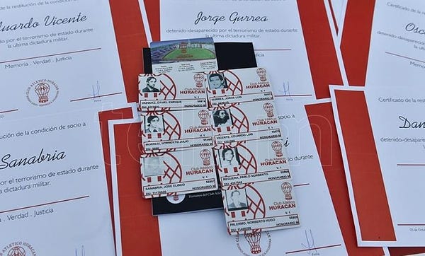 As oito carteirinhas de sócios do Huracán mortos e desaparecidos durante a última ditadura militar na Argentina sobre uma mesa. Ao lado delas, estão documentos de reconhecimento de socidade.