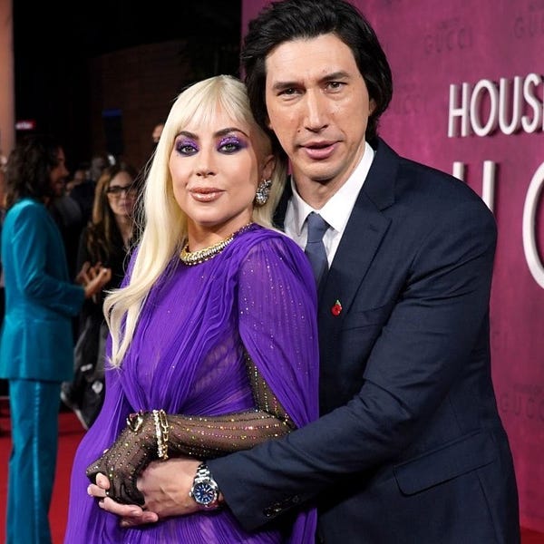 foto de divulgação do filme House of Gucci, com Lady Gaga em vestido azul e Adam Driver, abraçando Gaga, com terno azul marinho.