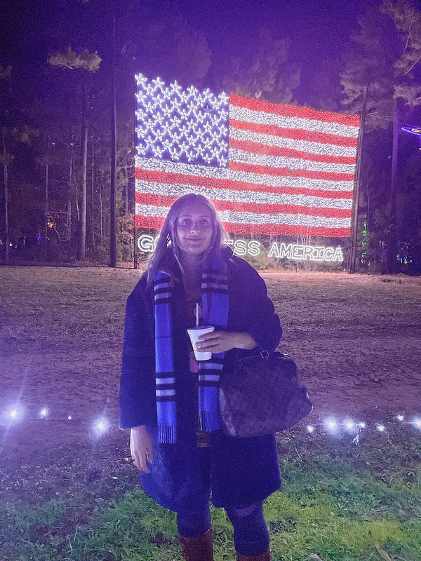Natalia in front of big American flag made out of lights