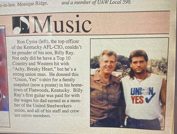A picture of a magazine section called Music. On the right is a picture of two people, Ron Cyrus who was the Kentucky AFL-CIO president and his son, musician Billy Ray Cyrus who is wearing a Union yes shirt with the sleeves cut off.