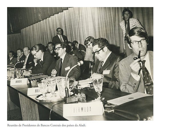 Foto sépia de mesa de evento. Legenda: Reunião de Presidentes de Bancos Centrais dos países da Aladi.