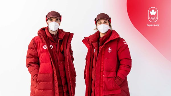 Two athletes, one man and one woman, stand in Team Canada's opening ceremony outfits. 