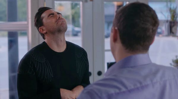 Schitt’s Creek Singles Week. David and Patrick in Rose Apothecary. Patrick Brewer to David Rose captioned “You're my Mariah Carey.” David wincing in response.