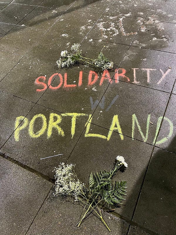 A message at the visual written in Chalk that says “solidarity w/ portland”