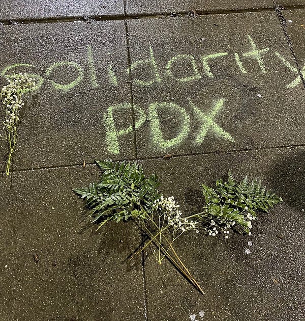 A photo of writing in chalk that says “solidarity pdx”