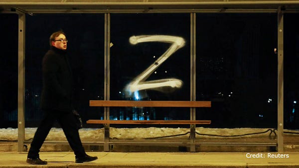 A man walks past the symbol "Z" painted on a bus stop in support of the Russian armed forces, in Saint Petersburg