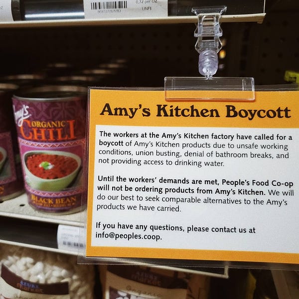Sign in a grocery store by the Amy’s kitchen products that reads “The workers at the Amy's Kitchen factory have called for a boycott of Amy's Kitchen products due to unsafe working conditions, union busting, denial of bathroom breaks, and not providing access to drinking water.”