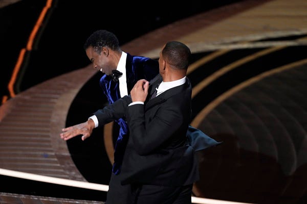 Will Smith appears to slap Chris Rock in the face.