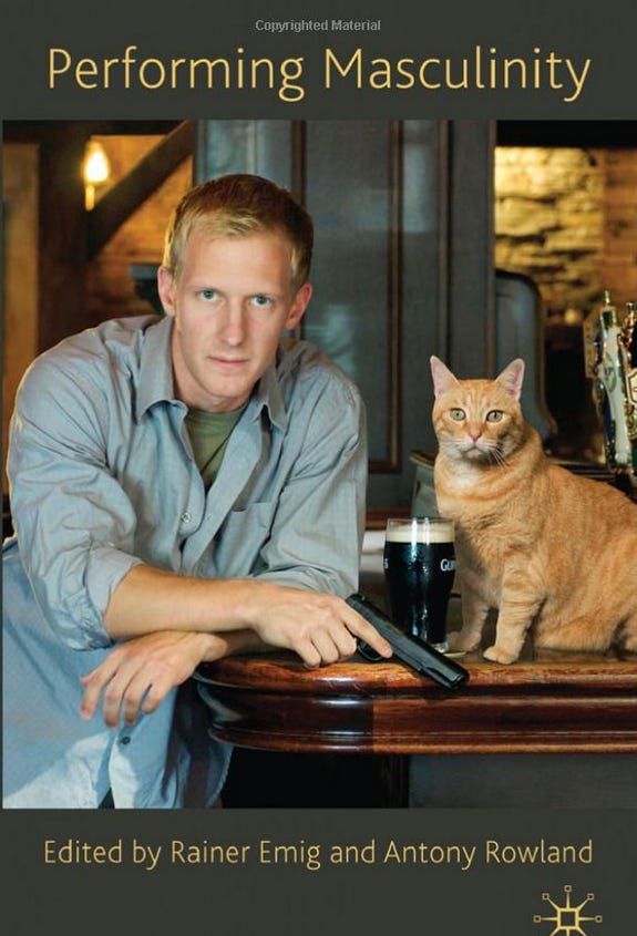 Depicted here is the cover of a book titled Performing Masculinity, edited by Rainer Emig and Antony Rowland. The cover shows a white man with blond hair leaning on a bar, looking directly into the camera. He's holding a gun. Next to him, on the bar, there's a pint of Guinness and a cat with red fur.