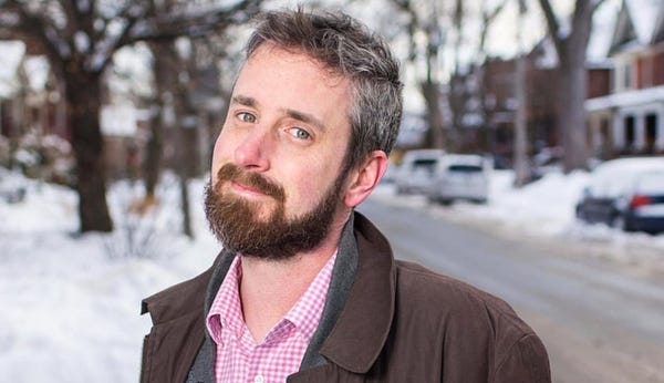 Chip Zdarsky smiles slightly as he stands outside on a snowy street, nose red from the cold.
