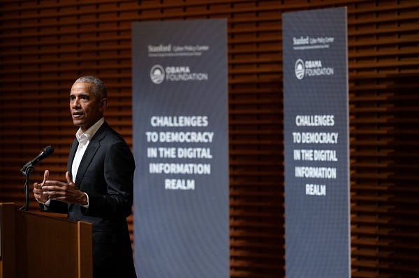 President Obama stands at a podium delivering a speech on disinformation and democracy at Stanford. 