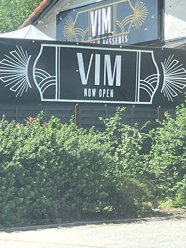 Restaurant sign reading “VIM: Now Open”
