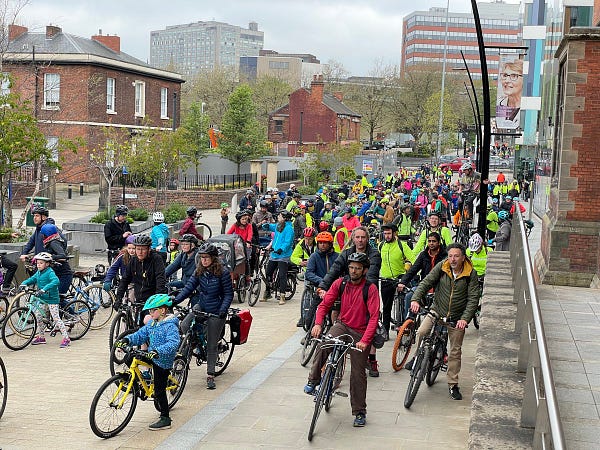 Over a hundred people on bikes waiting together