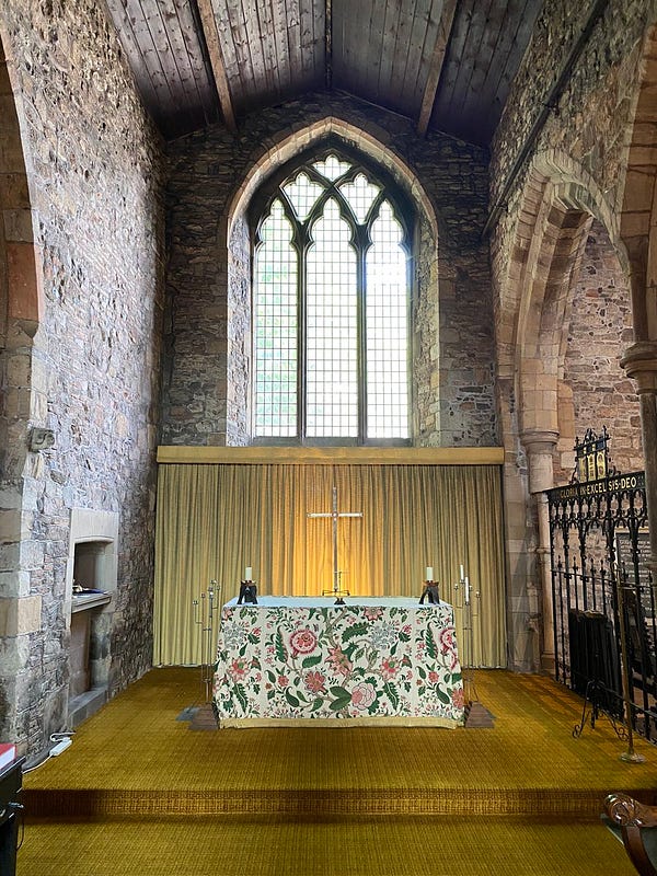 The high altar at the same church, beneath a large glass window letting in a significant amount of light.