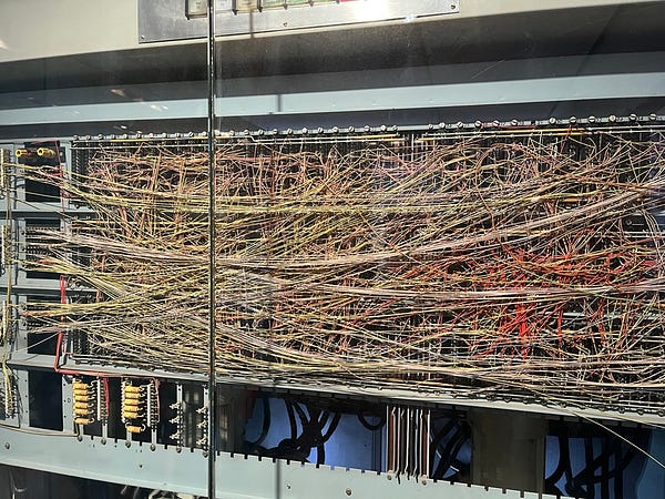 a backplane from the Z31 computer from 1962, thin wires in different colours strung densely in all directions across about 1m x 30cm