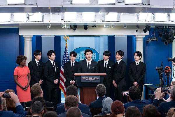 BTS stand at the Press podium with Press Secretary Karine Jeanne Pierre.