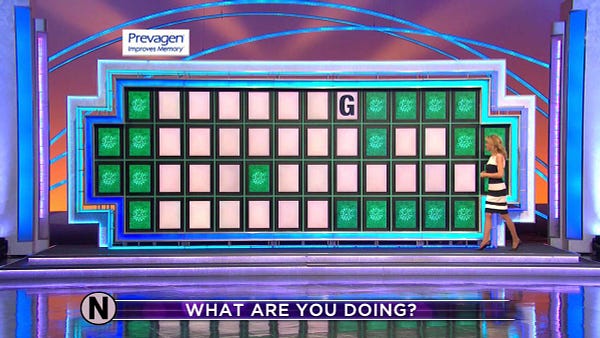 It's a wheel of fortune board. the clue is WHAT ARE YOU DOING? there are seven letters, seven letters, two letters, three letters, seven letters, and then six letters. the only letter visible is a G at the end of the first word.