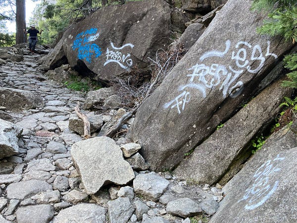 Blue and white tagging on granite, containing the words 559 and Fresno