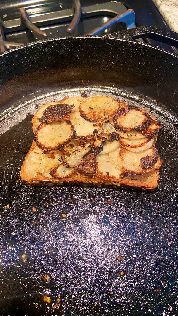 Heap of caramelized radish on a piece of toast on cast iron pan