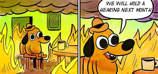 A comic depicting an unnaturally calm cartoon dog sitting inside his home in flames. He smiles and says "We will hold a hearing next month".