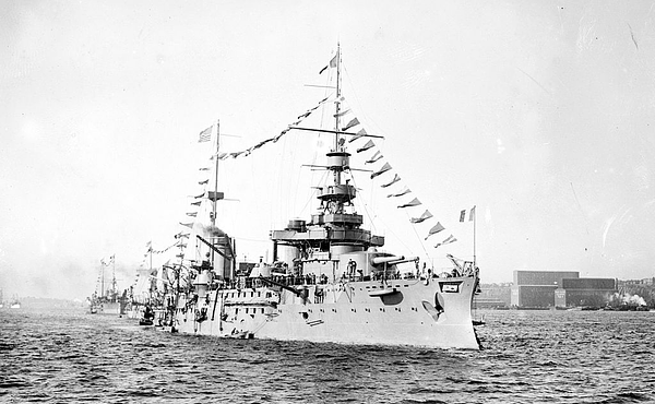 French Battleship Liberté at the head of a row of ships in port, fully dressed with flags. A shocking blast from within would later destroy it in seconds due to a failure at the highest levels of command, and I find no comfort in this metaphor.