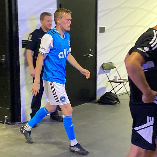 Karol Swiderski walking out to the pitch at halftime in Charlotte FC’s blue home kit.