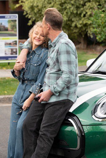 Charlene and Scott kissing in front of a green mini on the set of Neighbours