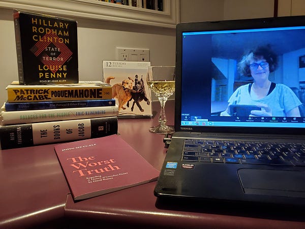 Me, on screen, getting ready for a silent book club zoom meeting, with my stack of books and a glass of wine next to the computer