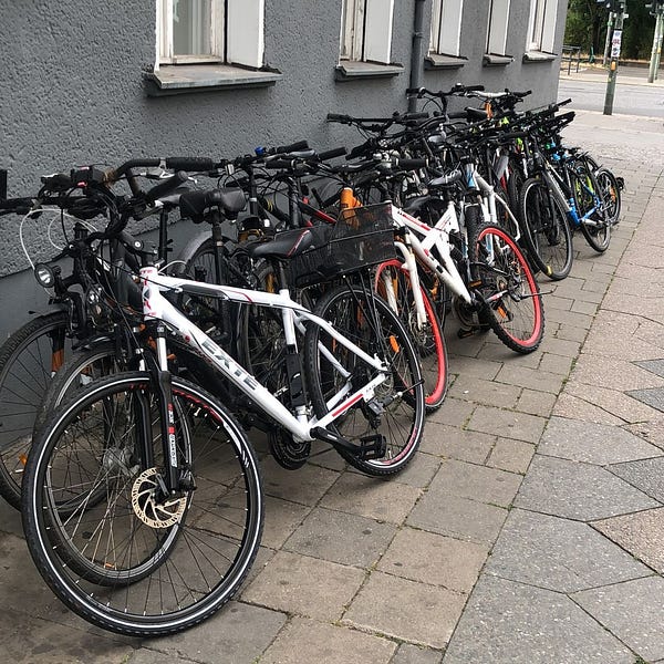 28 Fahrräder lehnen an einer Hauswand.