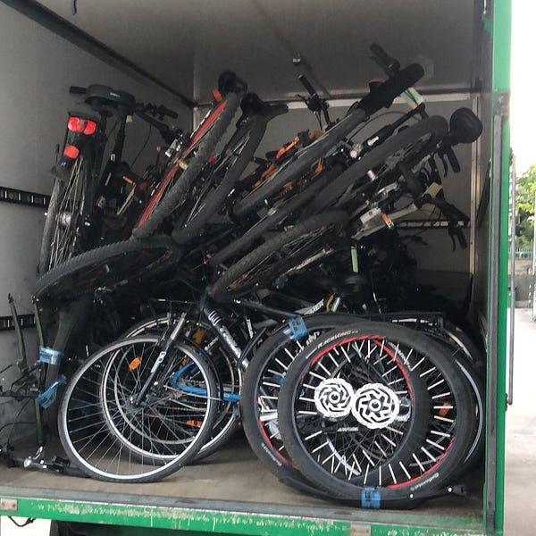 Fahrräder werden auf einen Transporter geladen.