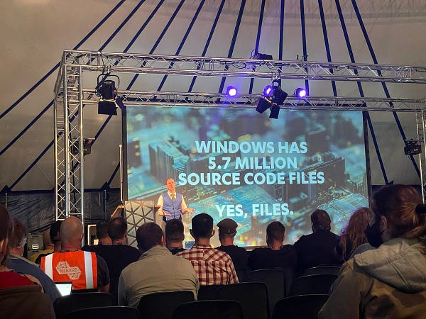 Picture of a slide with the text “Windows has 5.7 million source files. Yes, files.” With a presenter in front of the slide