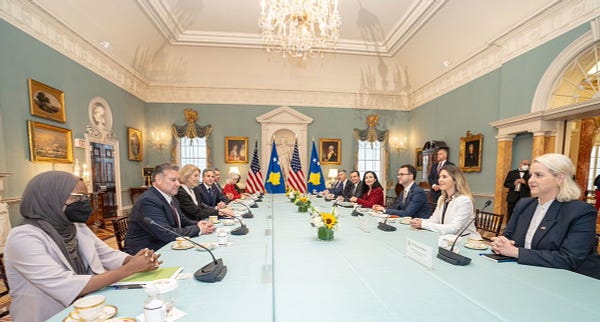 Photo of Secretary Blinken's meeting with Kosovo President Vjosa Osmani and Kosovo Prime Minister Albin Kurti. People sitting on both sides of a long table. 