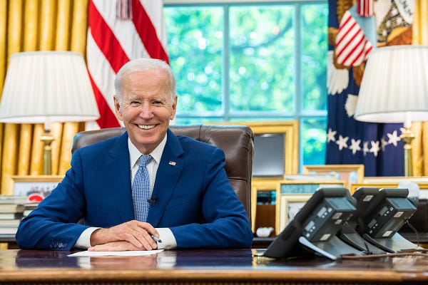 President Biden sits at his desk.
