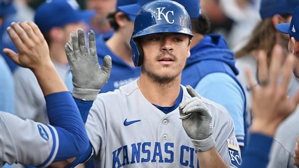 Nick Pratto high-fives teammates in the Royals dugout following a home run.